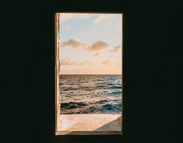View of the ocean through an open doorway, symbolizing hope and a path to freedom from financial abuse