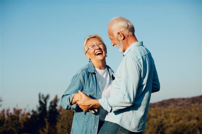two seniors who have been through a grey divorce hold hands and laugh